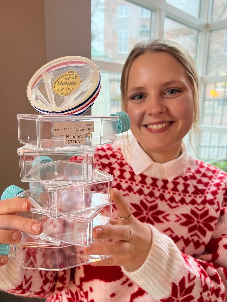 Stina holding the trophy for winning the prediction of the world cup in football 2022.